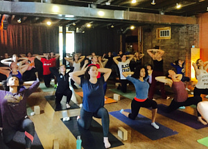 Members of the yoga outreach Year of Service group take a yoga class at Blooming Life Yoga Studio + School during Community Day.